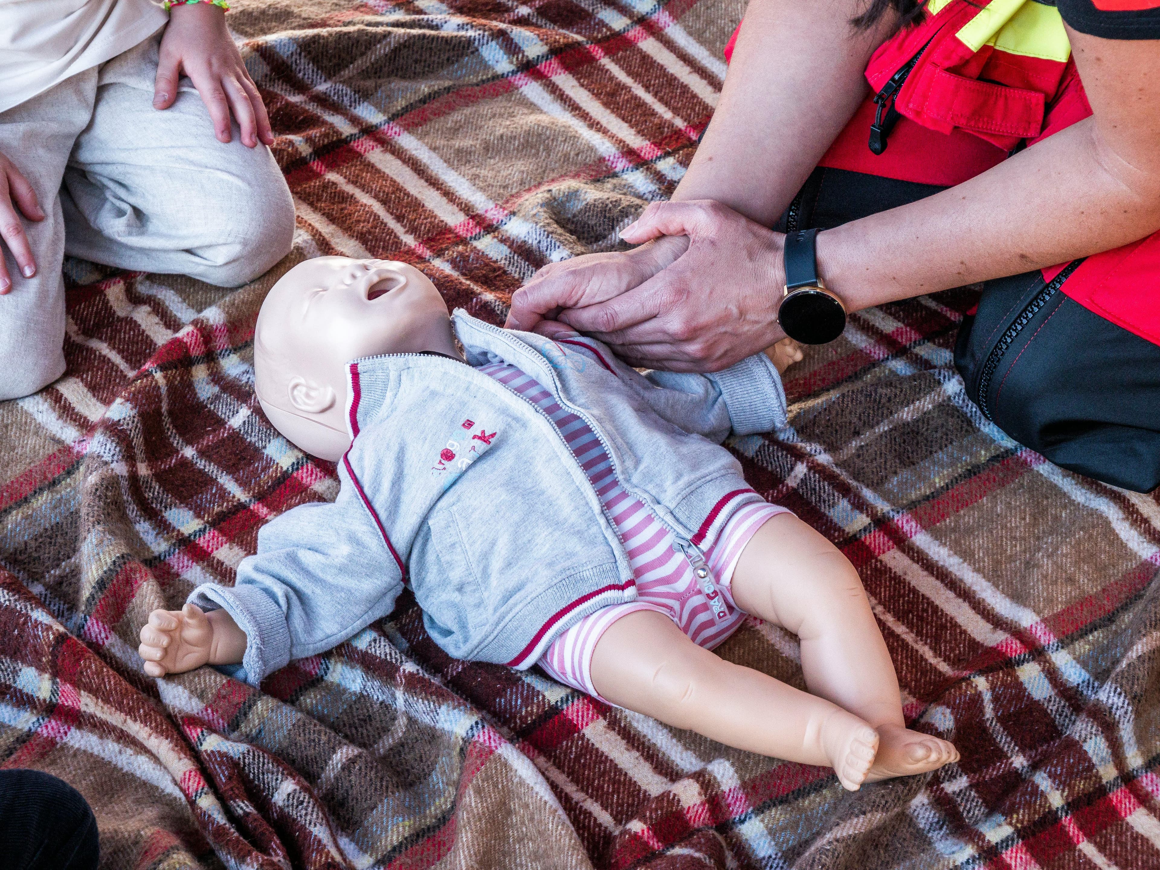 Teen learning basic caregiving and safety skills with supervision.