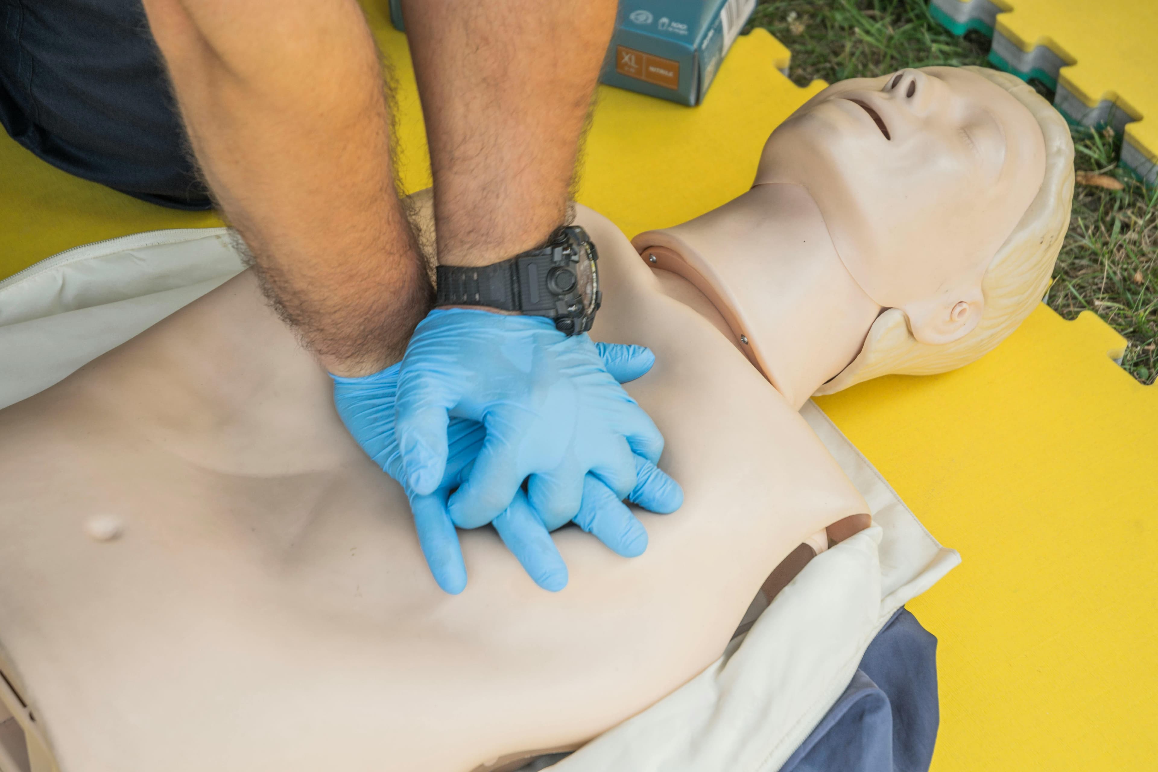 Close-up of hands performing chest compressions on a CPR manikin.