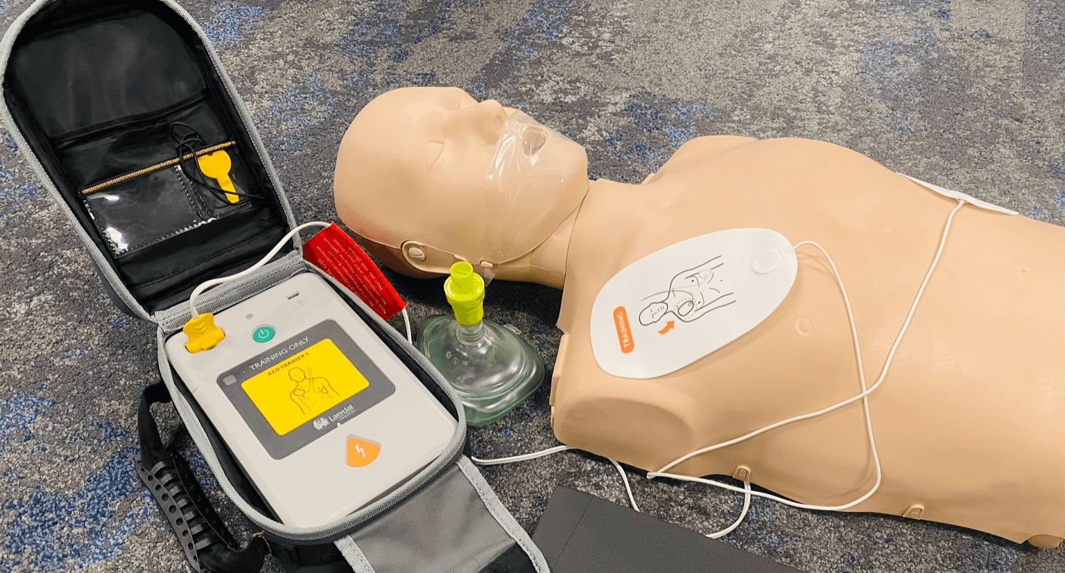 Close-up of hands performing chest compressions on a CPR manikin.