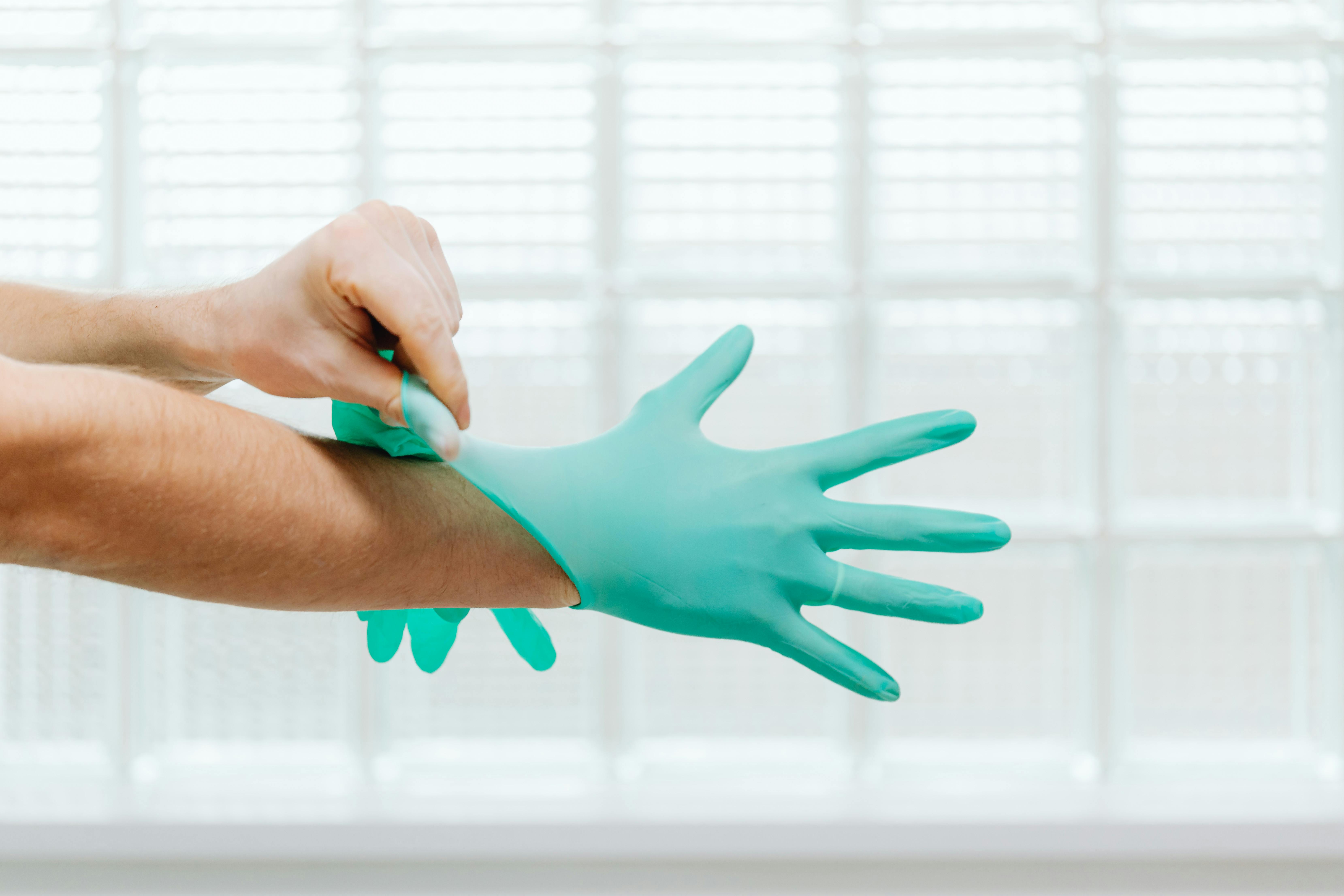 Gloved hands with PPE for bloodborne pathogen safety.